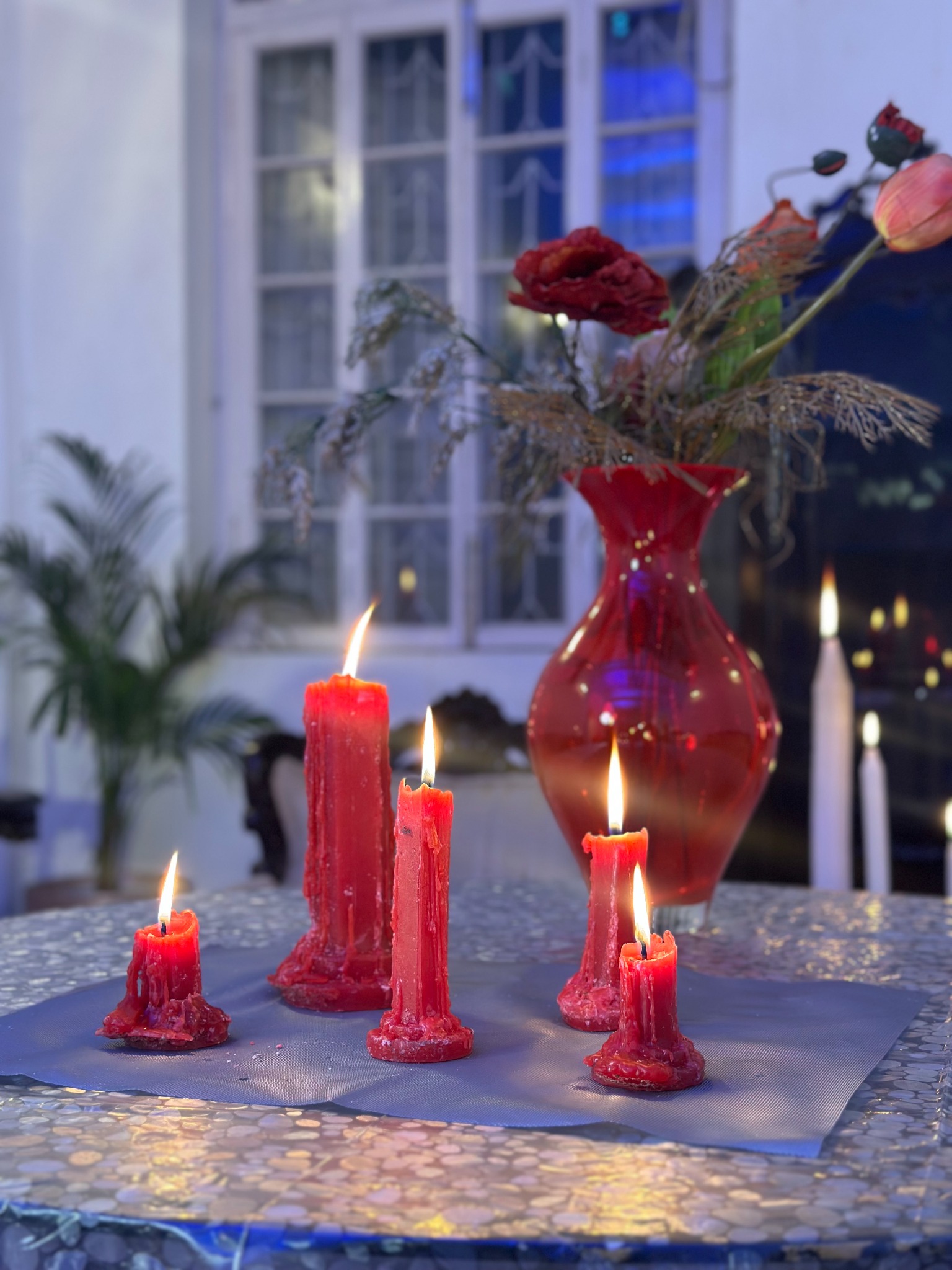 Red candles and flowers arranged for The Hundredth Chamber