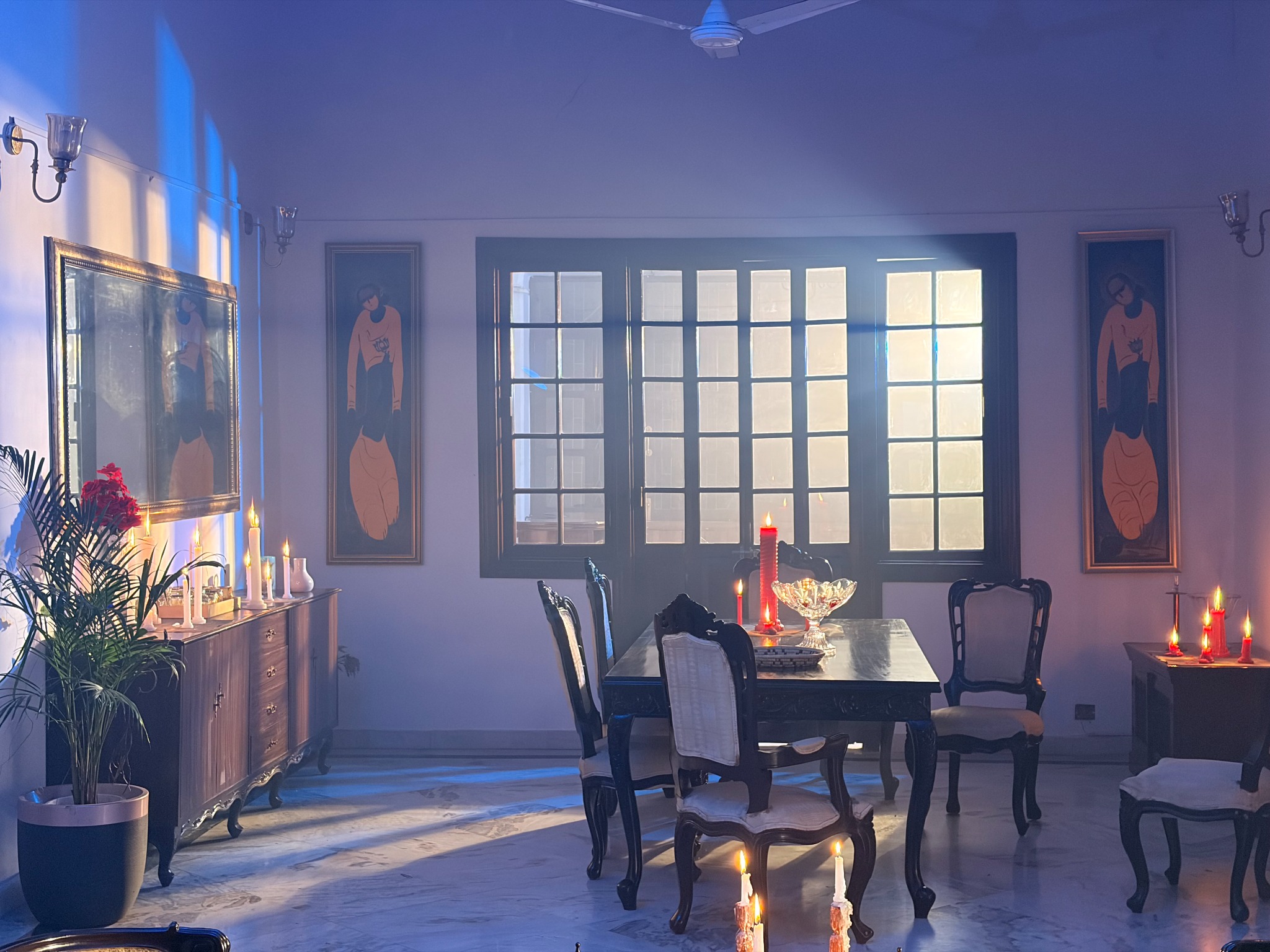 Candlelit dining table and heritage windows in atmospheric blue light