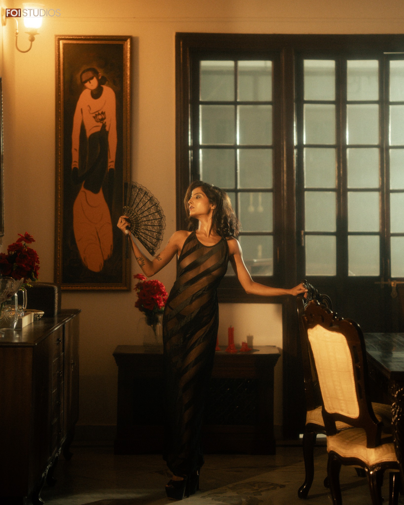 Debpriya posing with a black fan inside the heritage salon