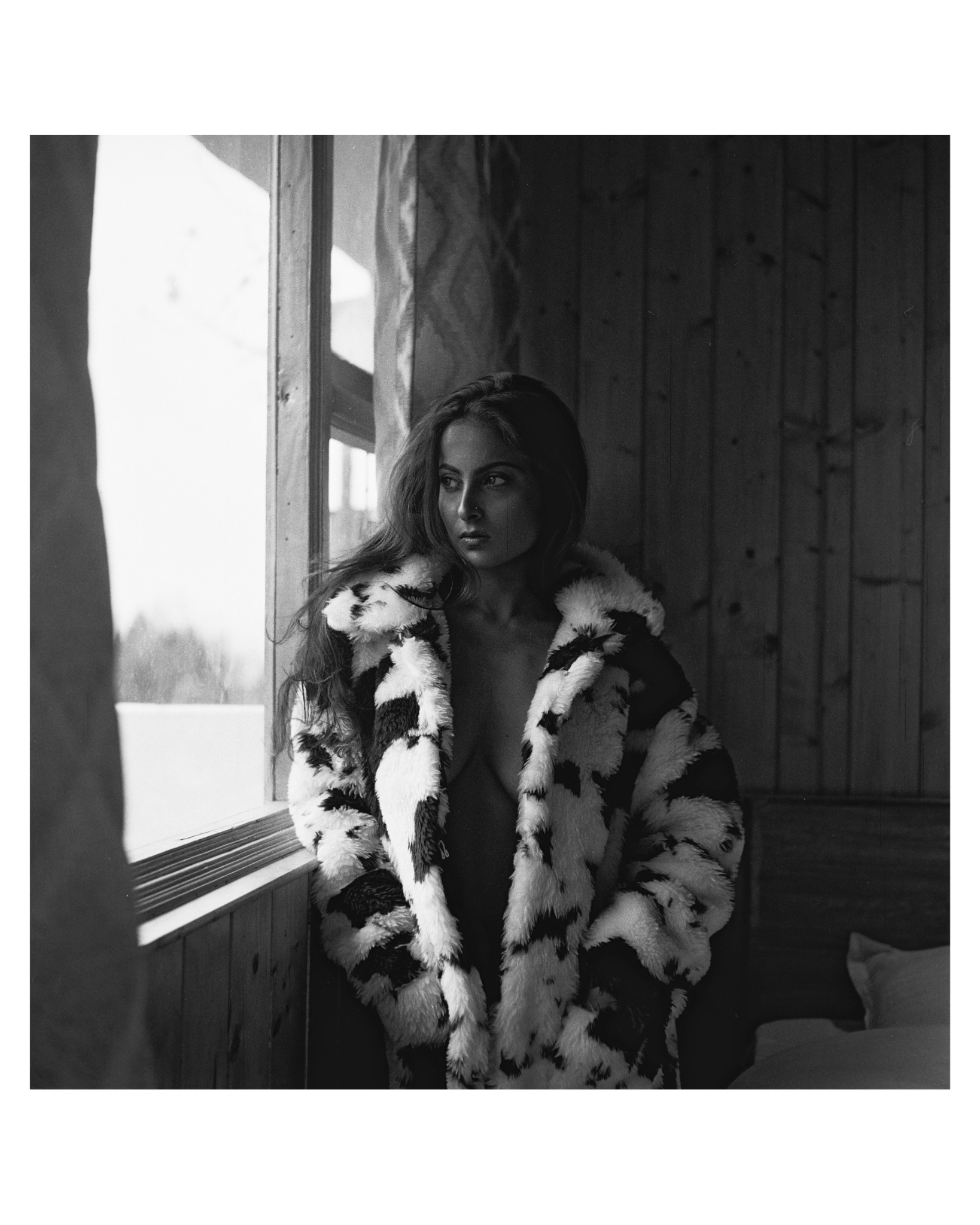 Black-and-white film portrait beside the cabin window