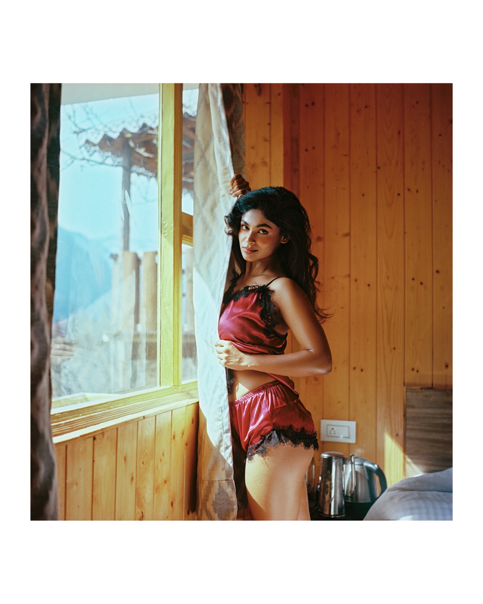 Morning light on red satin inside a wooden North Sikkim cabin